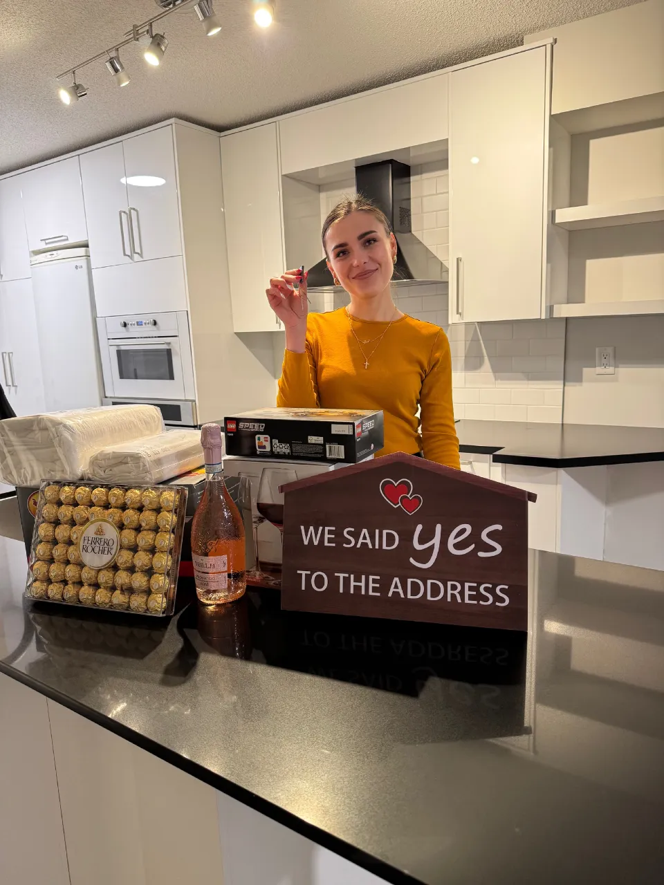 A client celebrating with her new house keys and a closing gift